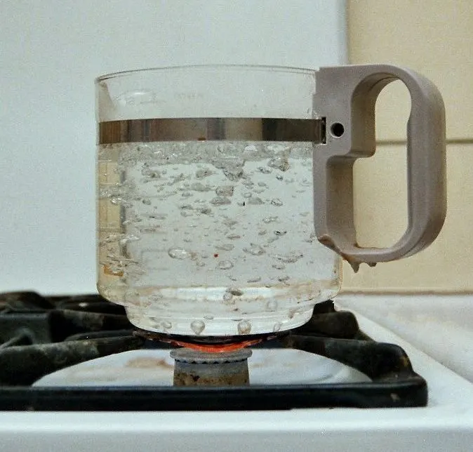 Water boiling in a glass jug on a gas cooker