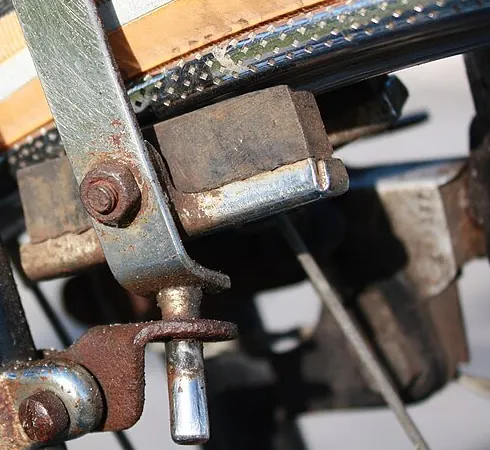 A bicycle brake block next to the metal rim of a wheel