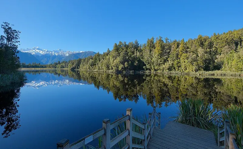 Mountains and forest reflected in a perfectly still lake