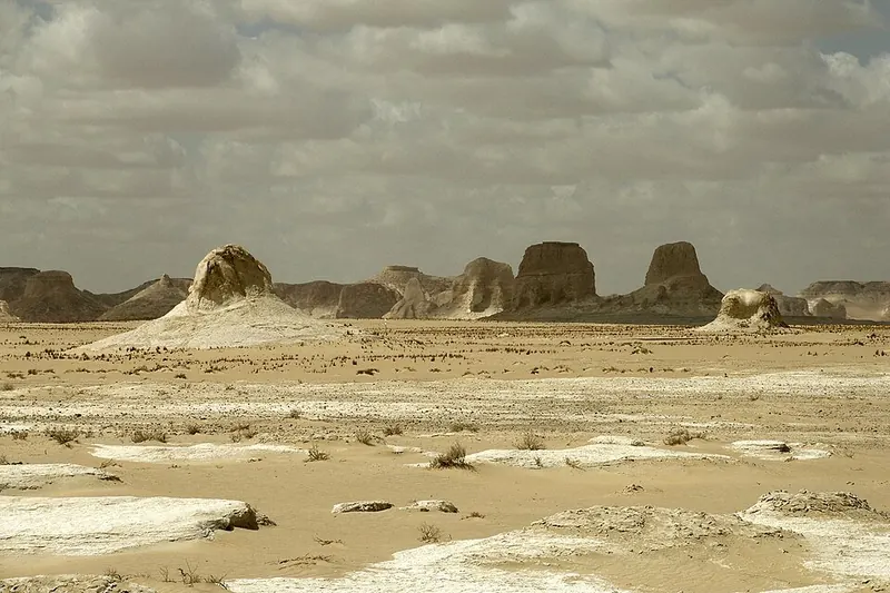 White chalk rock towers standing in a sandy desert