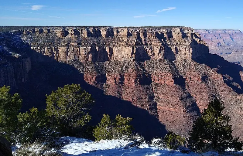 Canyon walls made of many horizontal bands of red and cream rock